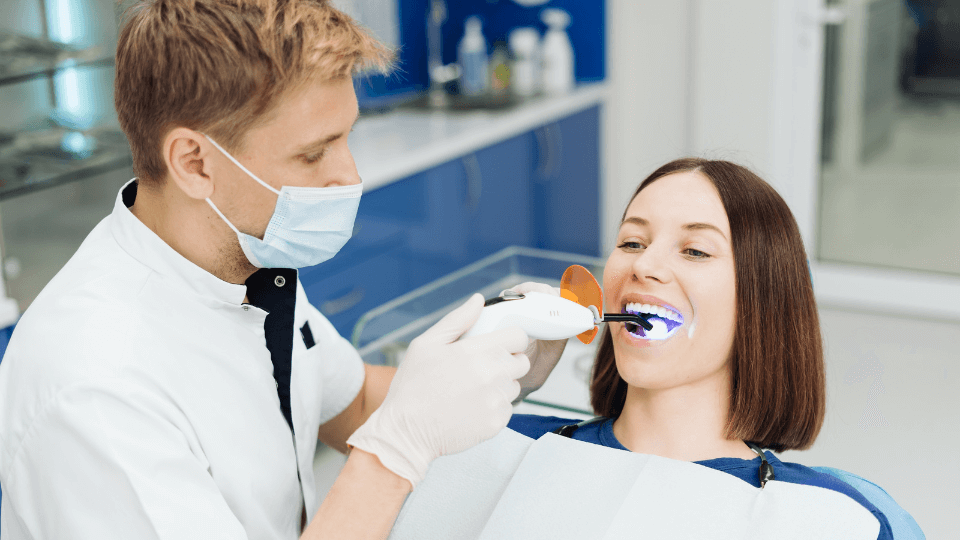 Dentista em processo de clareamento dos dentes